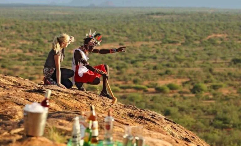 Maasai tour guide with tourist on a hill